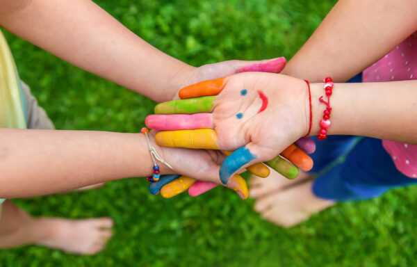 Hands of a child with a drawn smile. Selective focus.