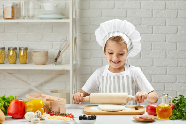 little child boy in cap and an apron cook